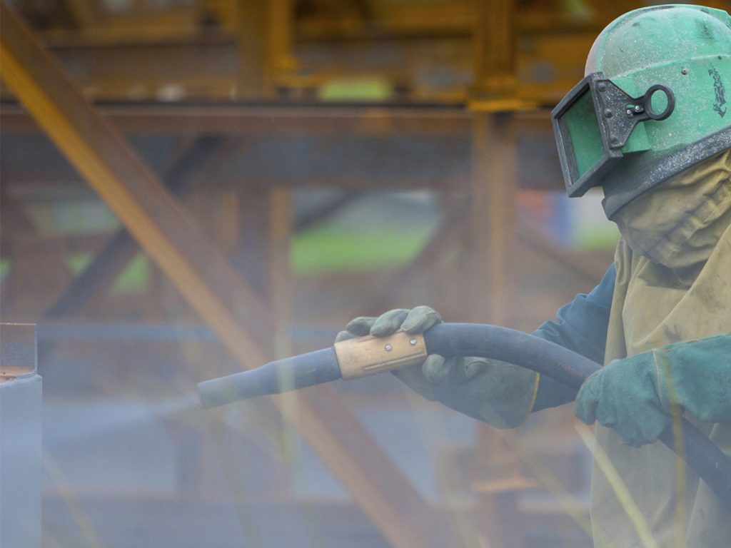 construction worker blasting air to clean hazardous waste
